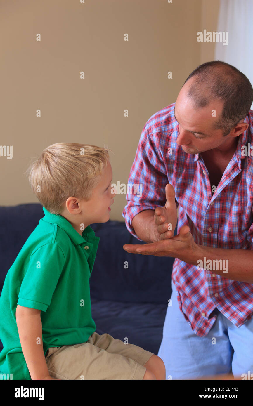 Father and son with hearing impairments signing 'stop' in American sign language Stock Photo