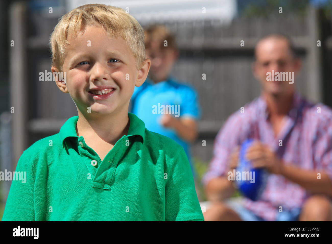Happy boy with father and brother with hearing impairments playing in backyard Stock Photo