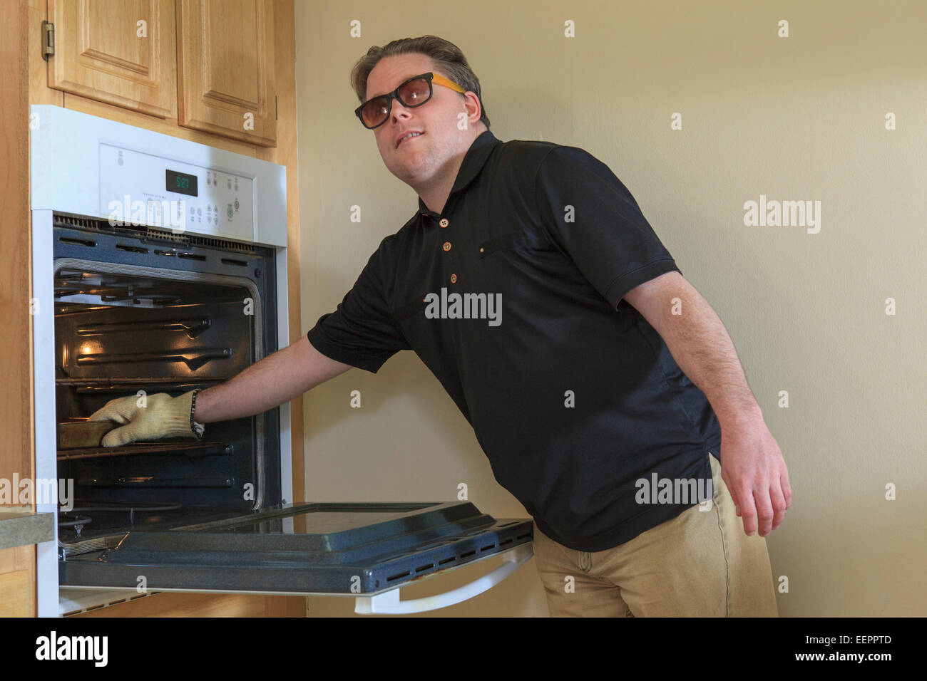 https://c8.alamy.com/comp/EEPPTD/man-with-congenital-blindness-using-the-oven-in-his-kitchen-EEPPTD.jpg