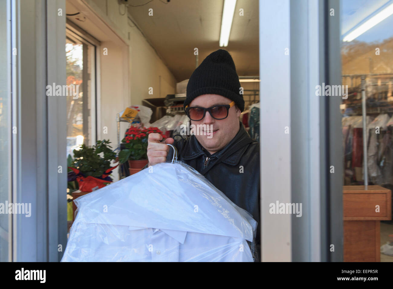 Man with congenital blindness picking up his dry-cleaning Stock Photo