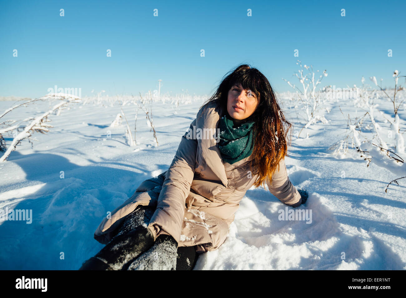 Beautiful girl sitting in the snow Stock Photo