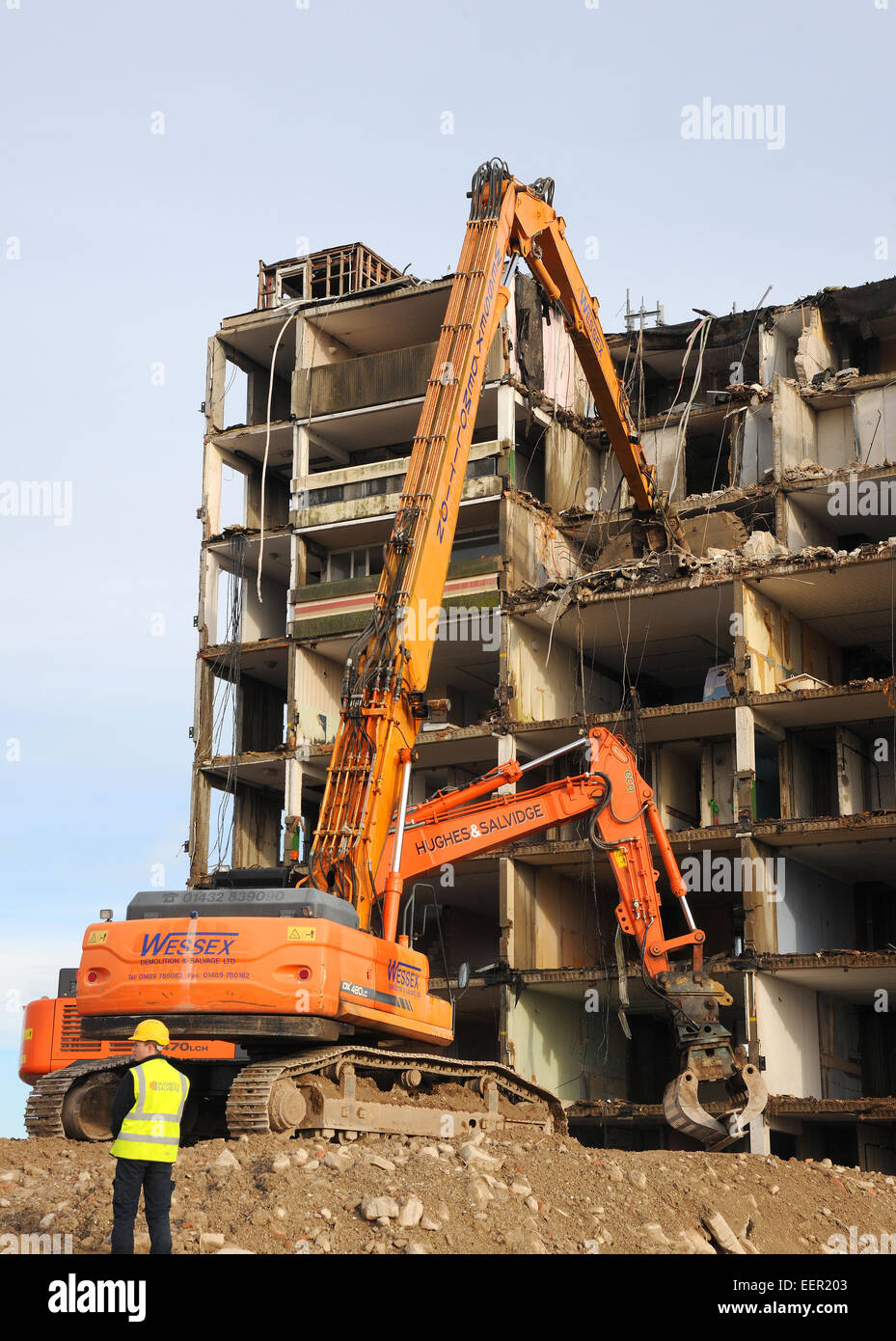 Debris falls from an upper storey as an apartment block is turned rubble as plant machinery destroys the structure. Stock Photo