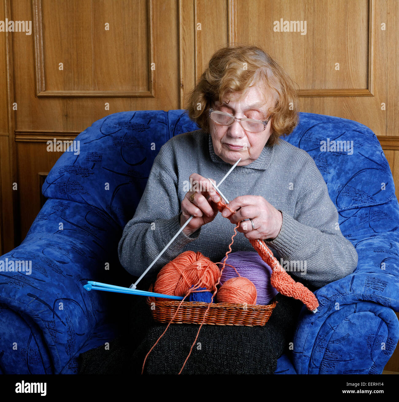 The old woman sits in an armchair and knits Stock Photo - Alamy