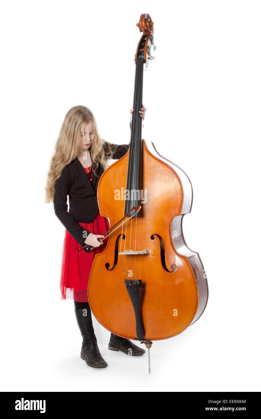 young blond girl in red dress plays double bass in studio against white background Stock Photo