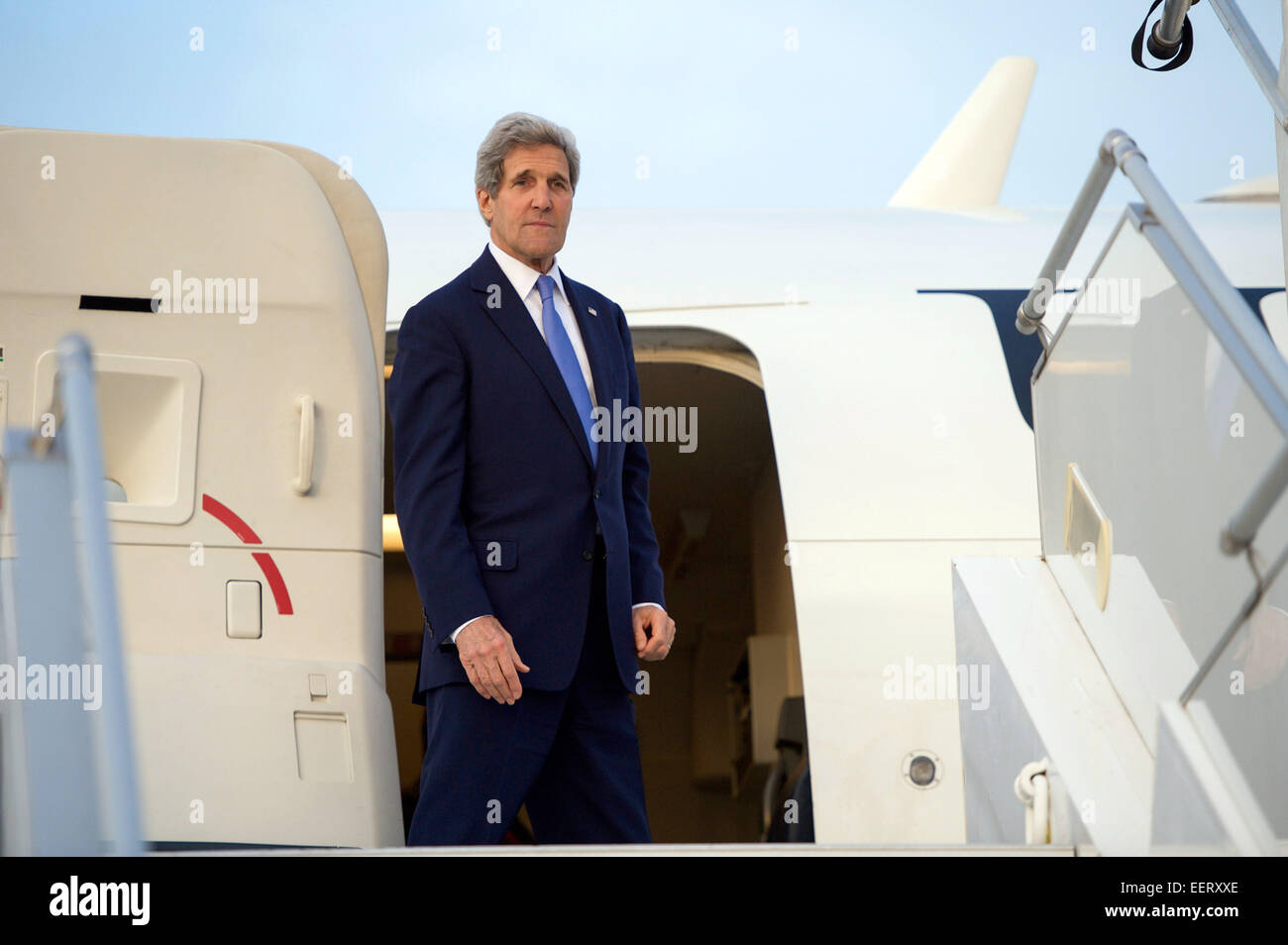 US Secretary of State John Kerry stands at the stop of the stairs outside his airplane before waving goodbye at LeBourget Airport January 16, 2015 in Paris, France. Stock Photo