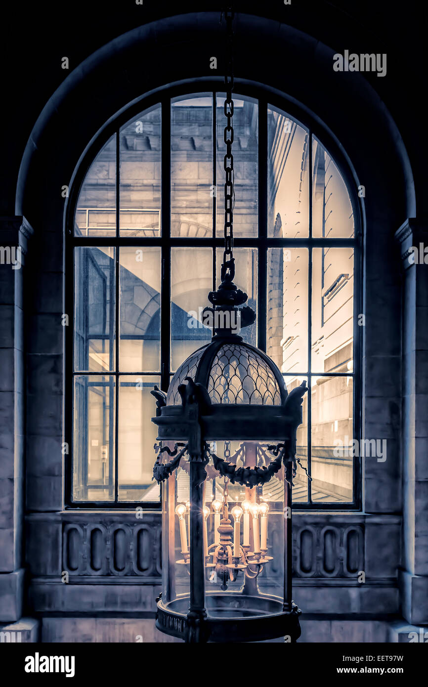 A hanging lantern in front of an arched window at the NYC public