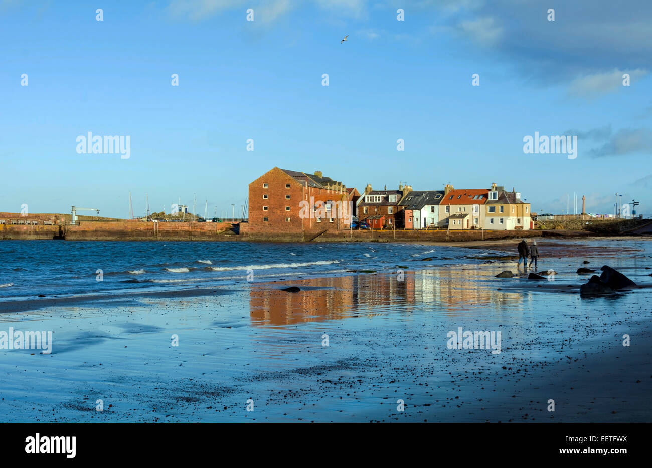 Buildings around North Berwick harbour are relfected in wet sand on the
