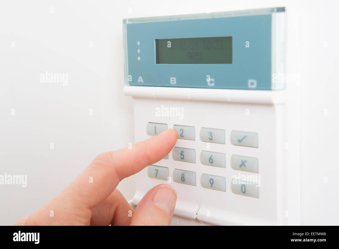 Woman Setting Control Panel On Home Security System Stock Photo