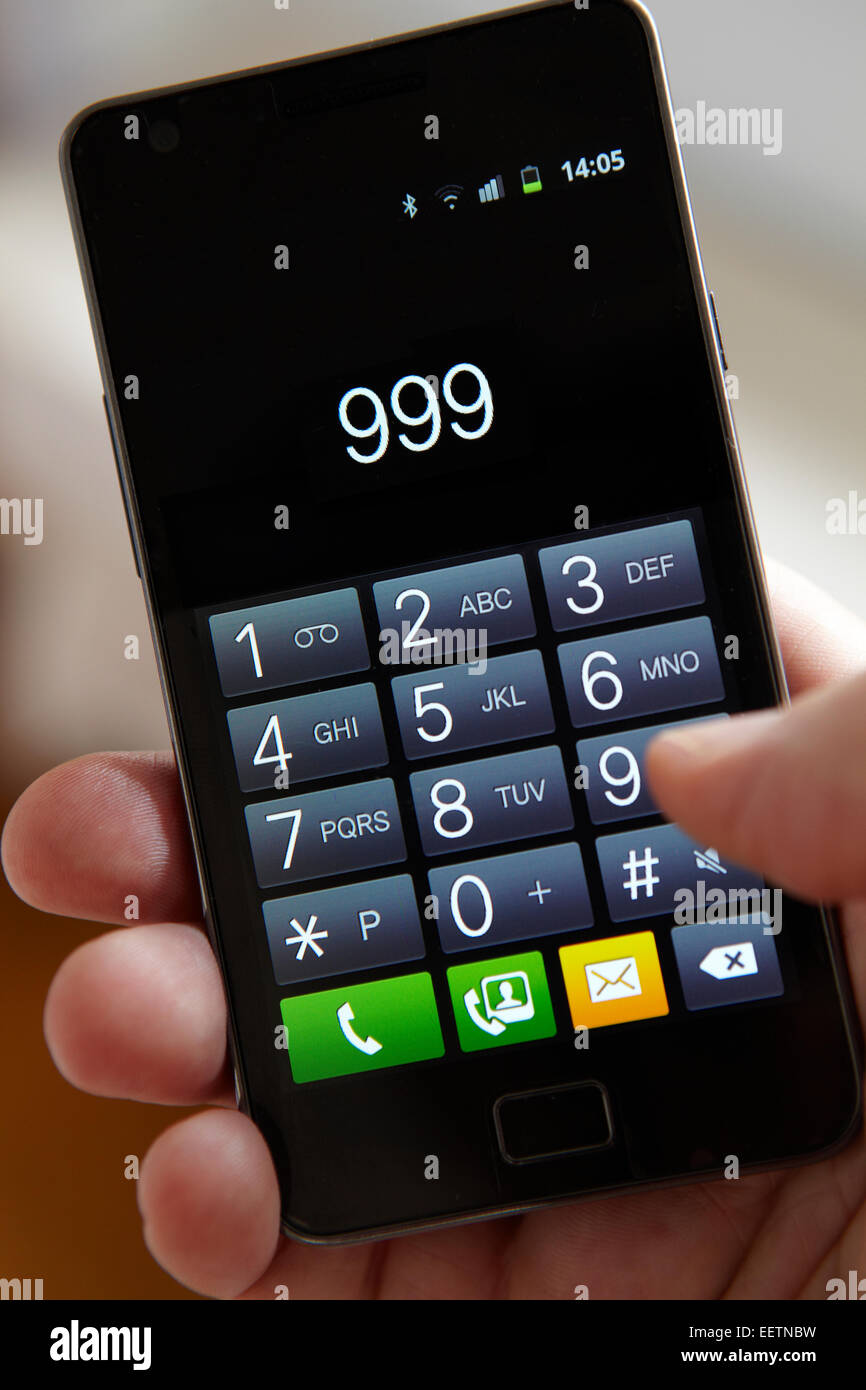 Hand Dialling 999 On Mobile Phone Stock Photo