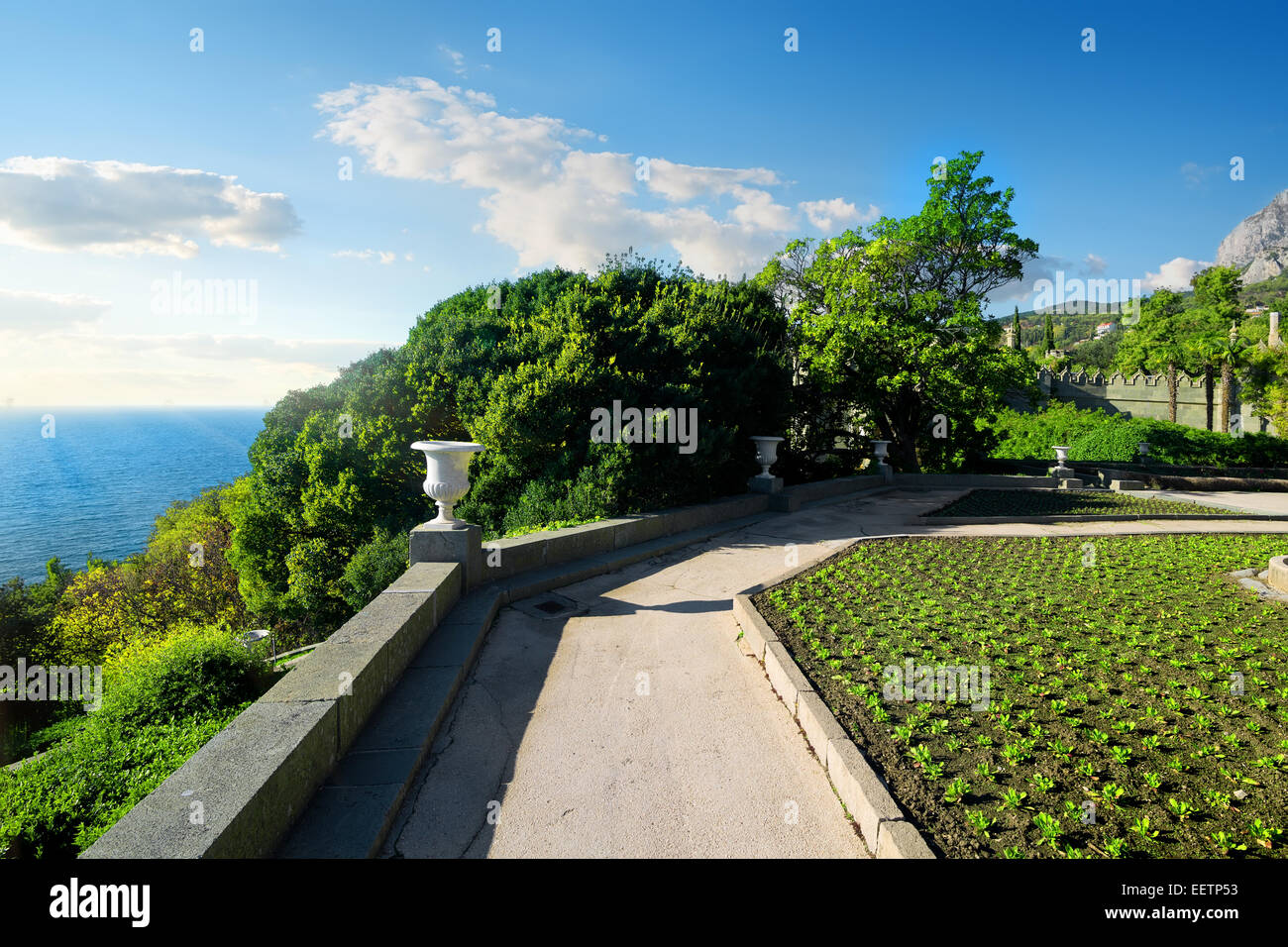 Alley and green flowerbeds with the view on sea Stock Photo