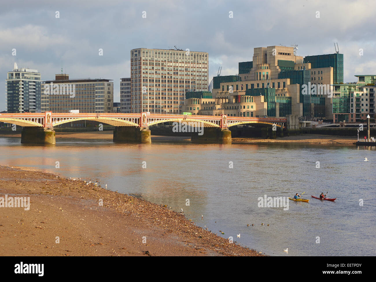 Vauxhall bridge with the Secret Intelligence Service or MI6 building on South Bank and rowers on the river Thames London England Stock Photo