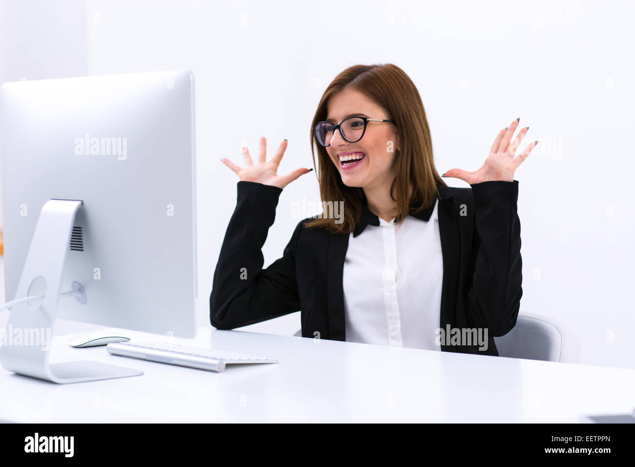 Portrait of a happy busiensswoman sitting at her workplace in office Stock Photo