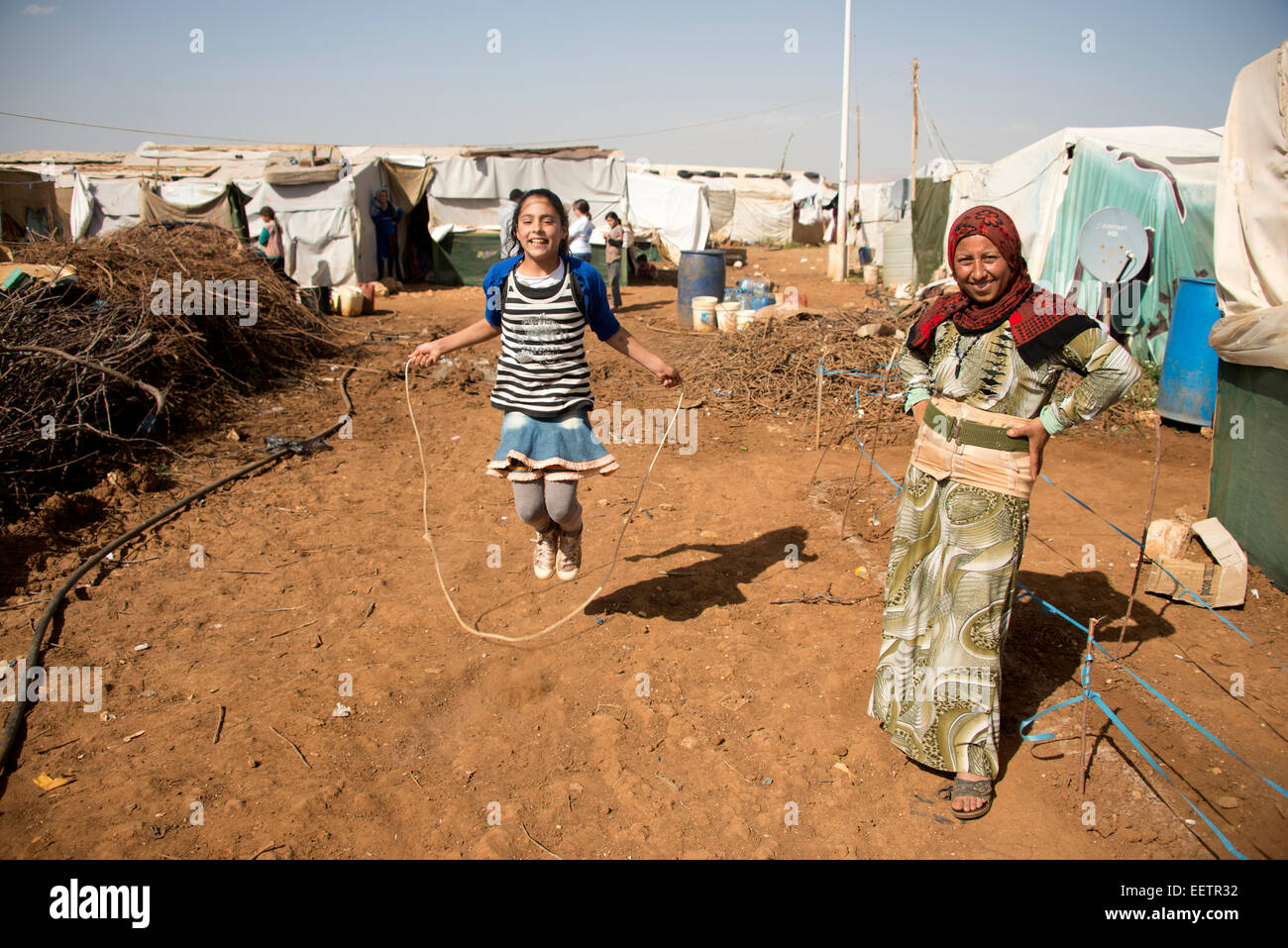 Syrian girl skipping in refugee camp, Lebanon Stock Photo