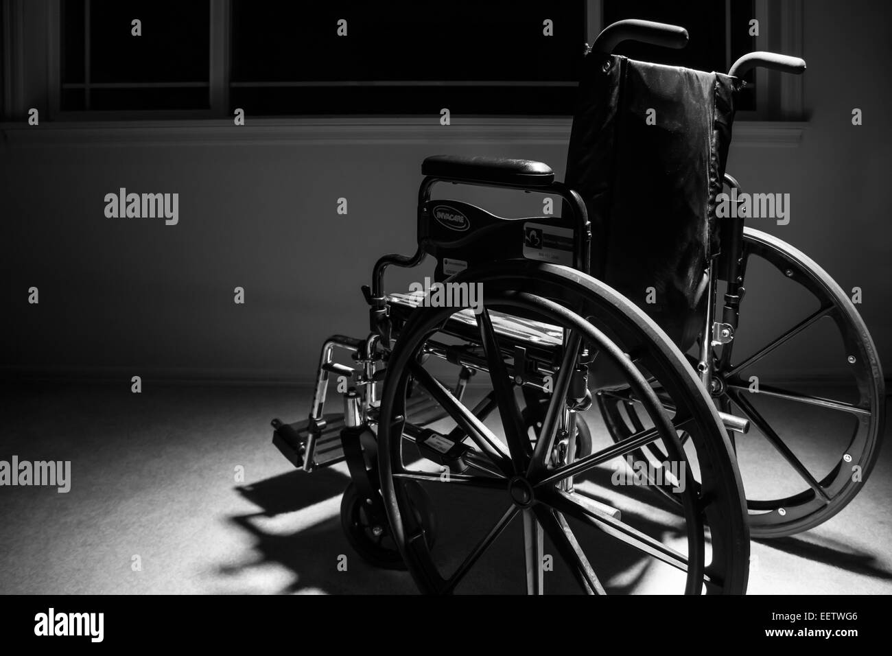 Wheelchair facing away, reinforcing the feeling of isolation and depression that can be associated with personal injury Stock Photo