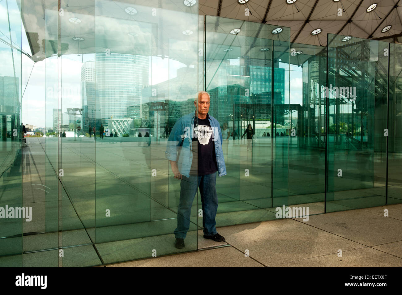 Mature male looking through panes of glass Stock Photo