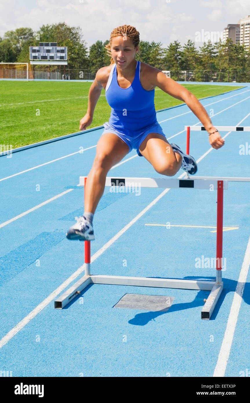 Woman Jumping Hurdles On A Track Stock Photo Alamy