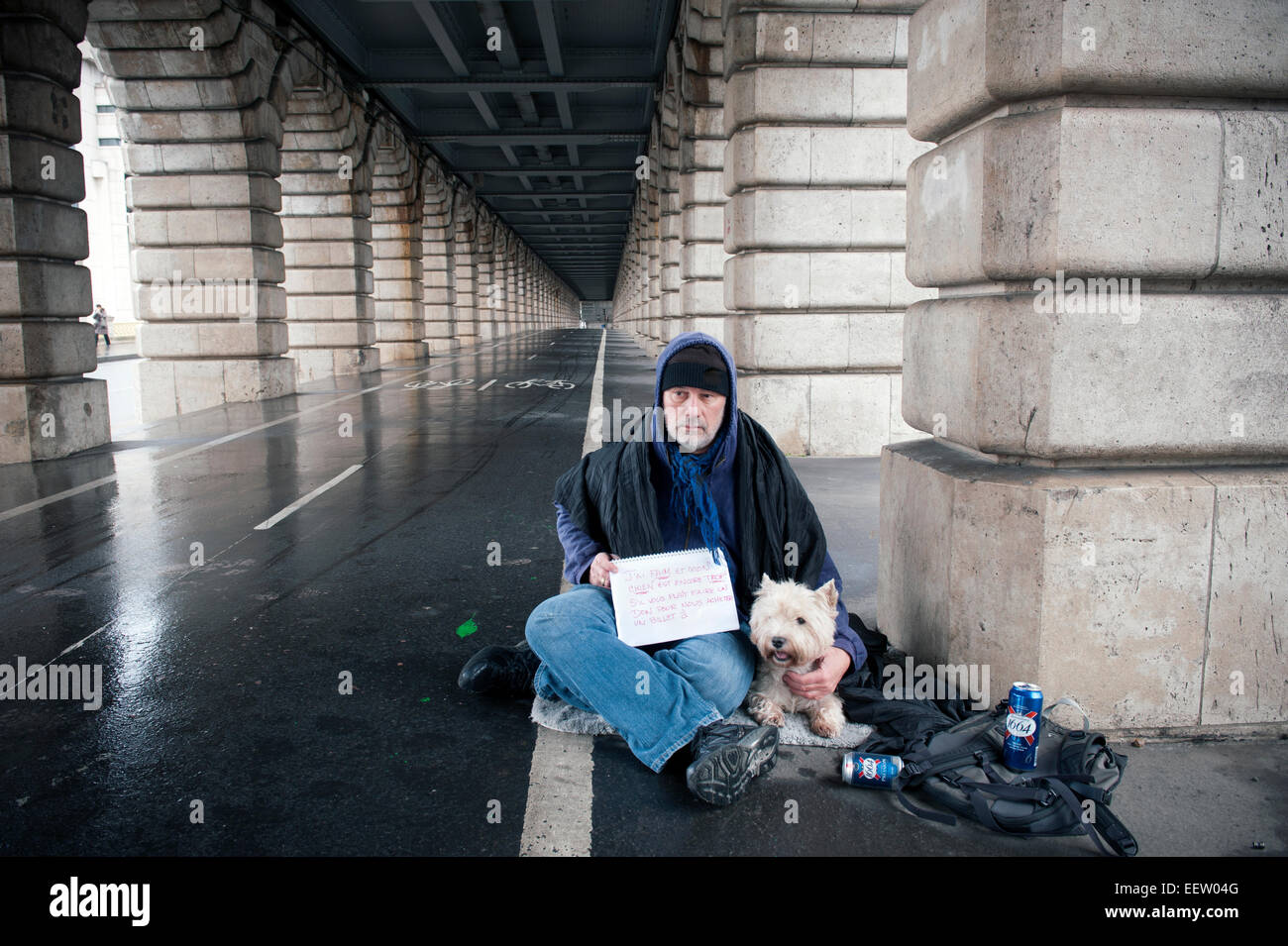 Homeless mature male with a dog under a bridge Stock Photo