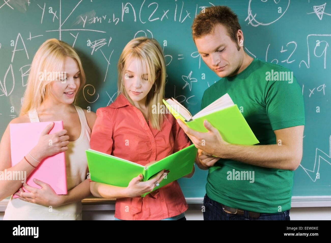 Three college students by a chalkboard Stock Photo
