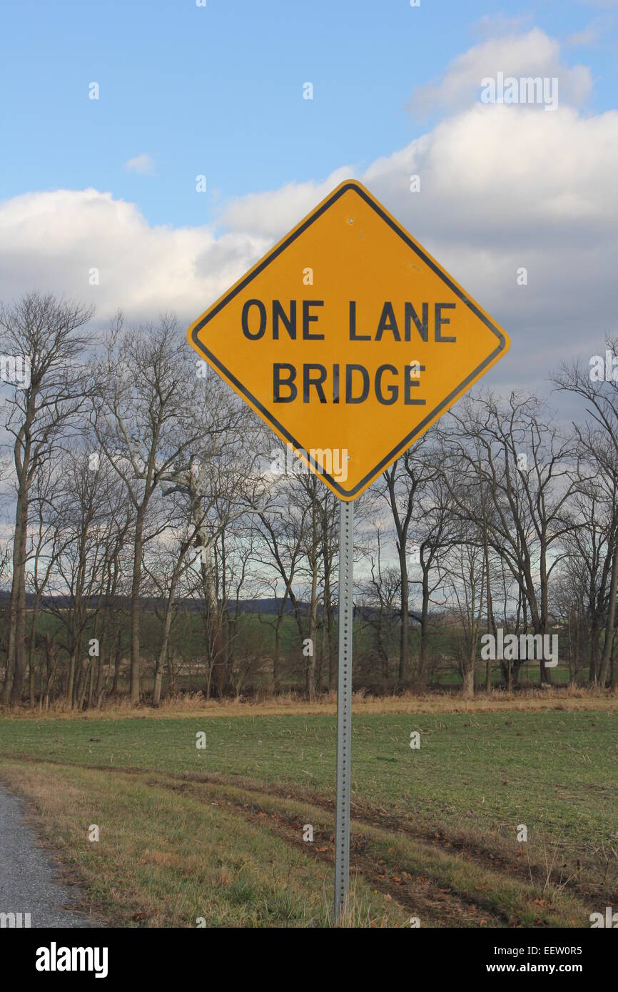 Yellow warning sign warning of one Lane Bridge ahead Stock Photo