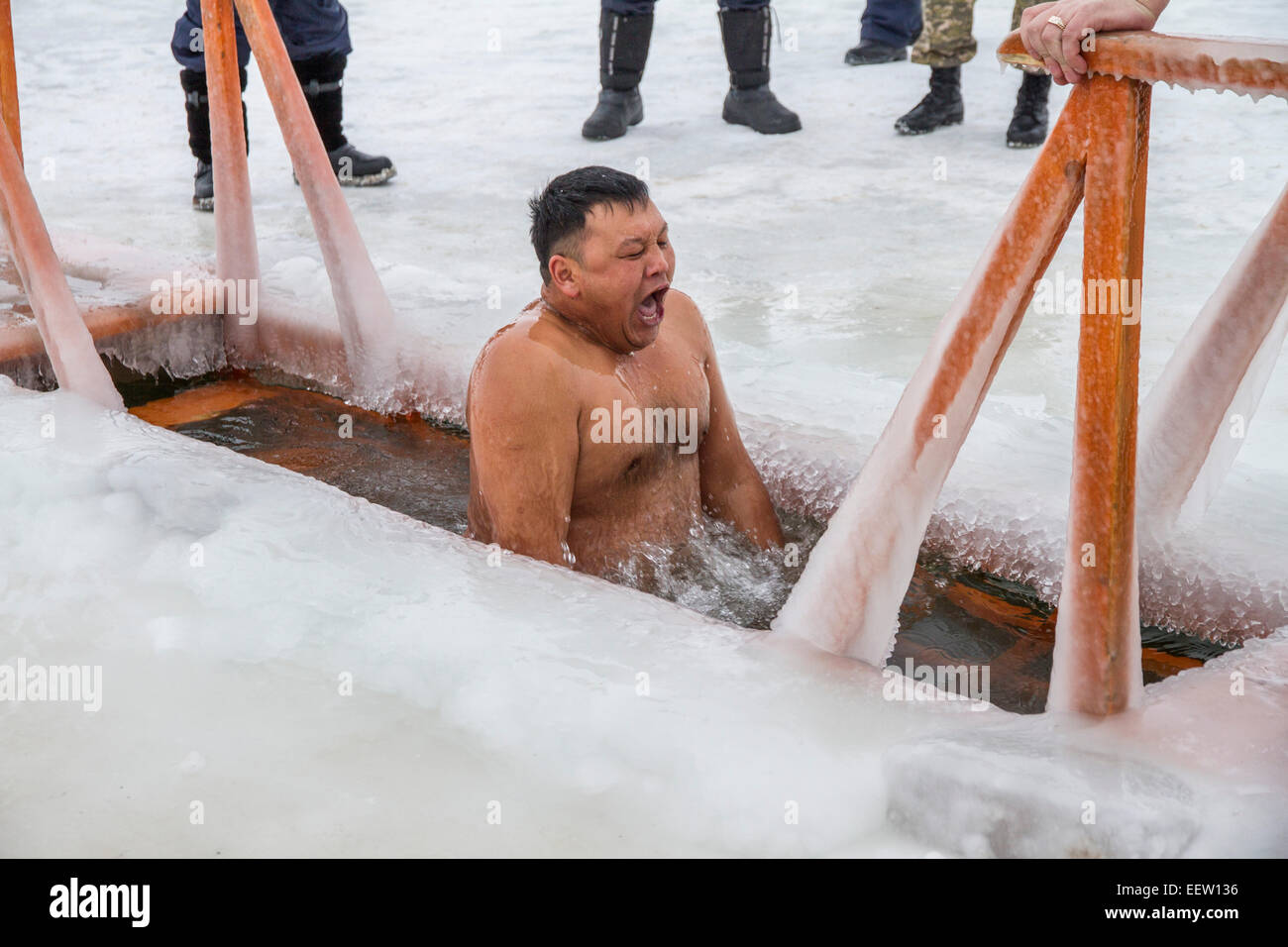 PETROPAVLOVSK, KAZAKHSTAN- JANUARY 19, 2015: Asian man dives into a hole. Orthodox church Holy Epiphany Day Stock Photo