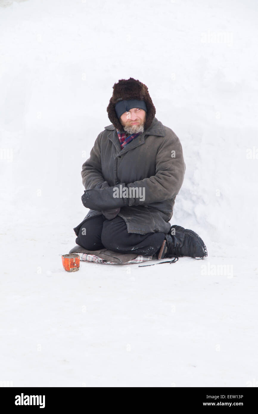 PETROPAVLOVSK, KAZAKHSTAN- JANUARY 19, 2015: Homeless man begging on holiday. Orthodox church Holy Epiphany Day Stock Photo