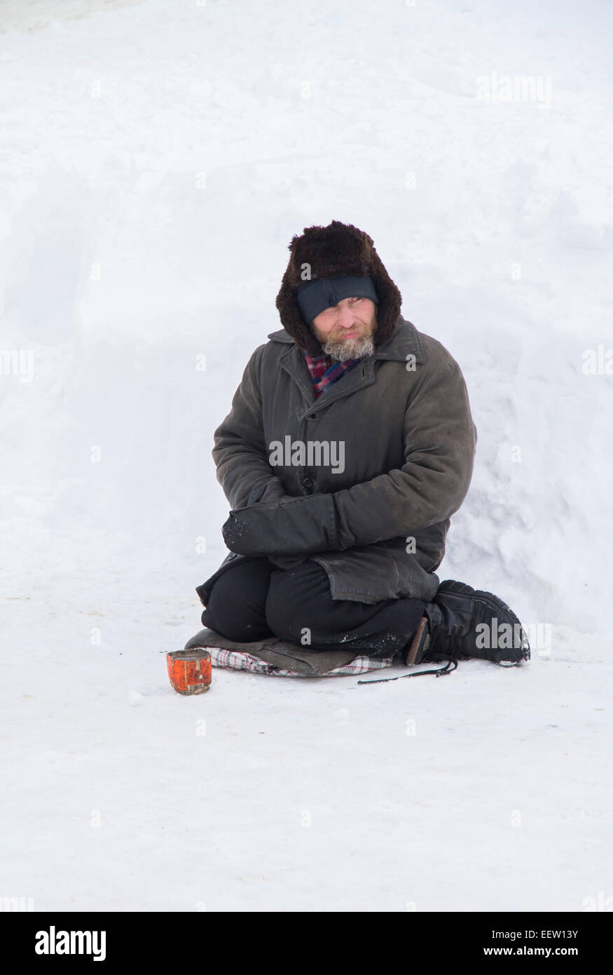 PETROPAVLOVSK, KAZAKHSTAN- JANUARY 19, 2015: homeless man begging. Orthodox church Holy Epiphany Day Stock Photo