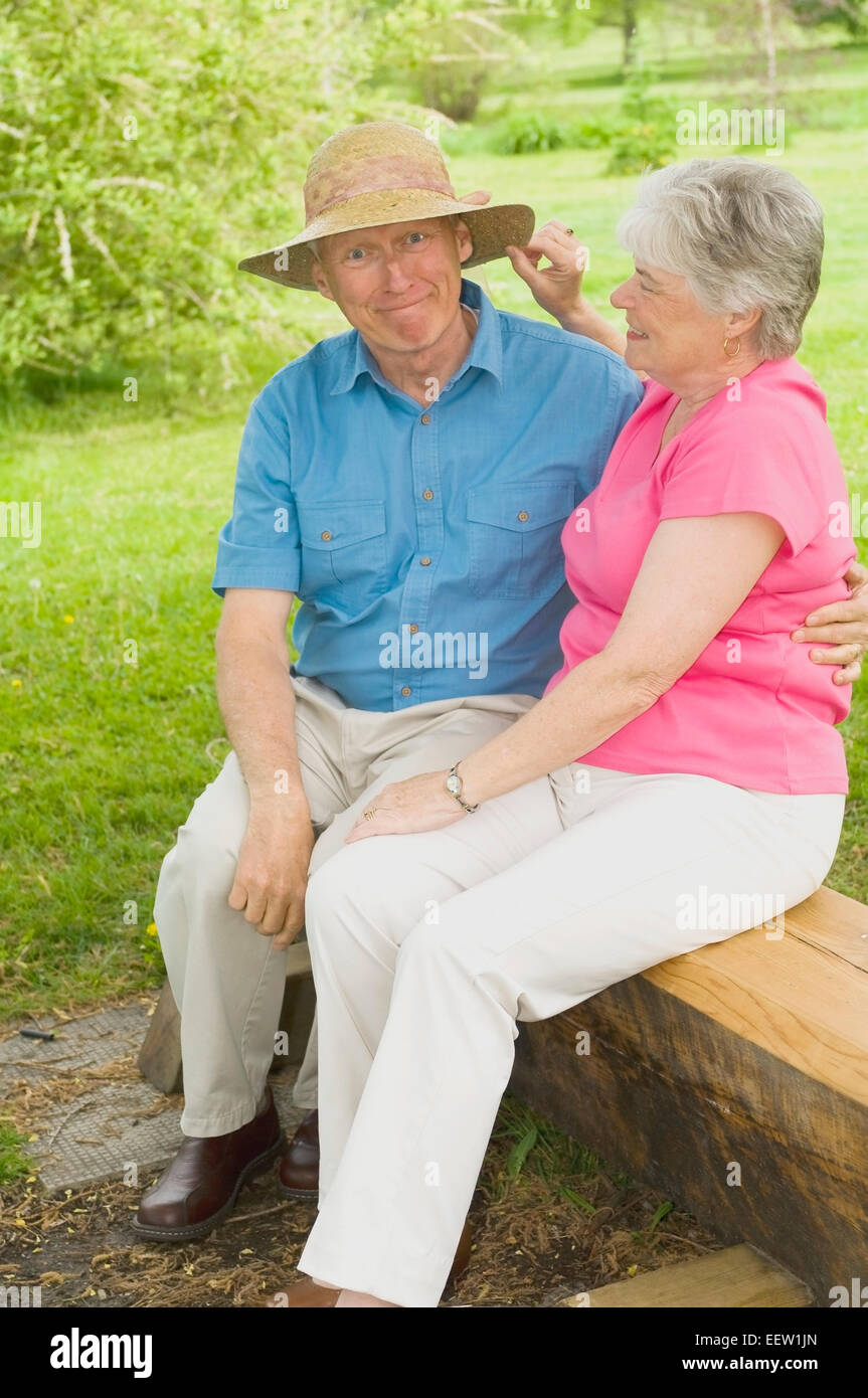 Playful senior couple on bench Stock Photo