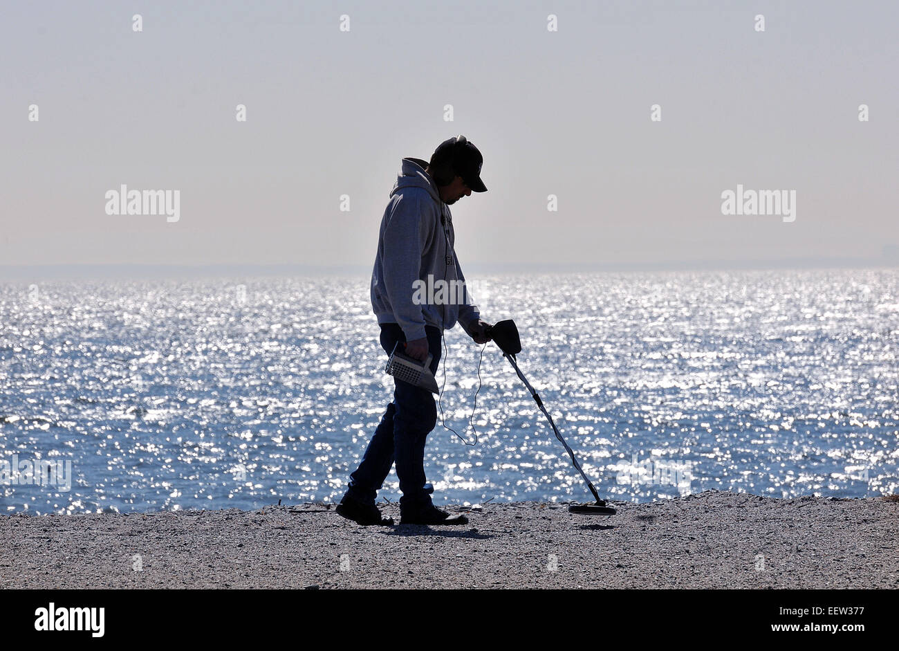 Milford CT USA-- Bill Plantamura enjoys the mild winter weather as he uses his new 'toy,' a metal detector, at Bayview Beach in Milford. Plantamura is from Milford. Stock Photo