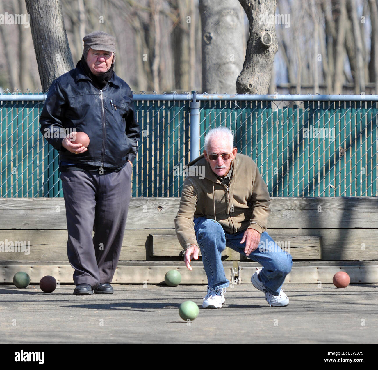West Haven CT USA- Ralph Manzo of West Haven rolls during a game of Bocci, as Matteo Diurno of New Haven looks on at the West Haven boardwalk courts. The two were enjoying today's weather and looking forward to Thursday, where temps are projected to be in the mid-60s'. Stock Photo