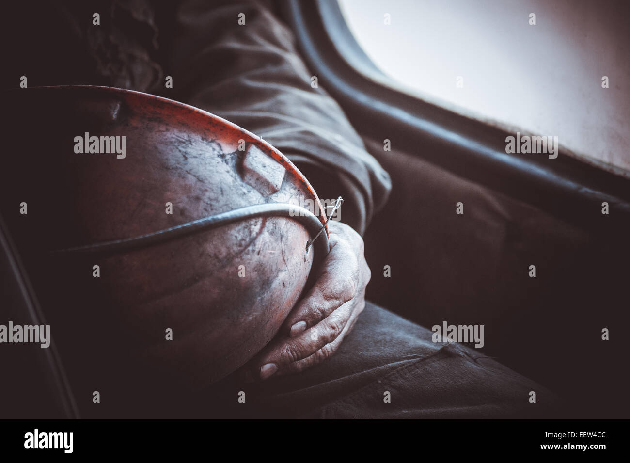 dirty hands of miner worker hold helmet no face Stock Photo