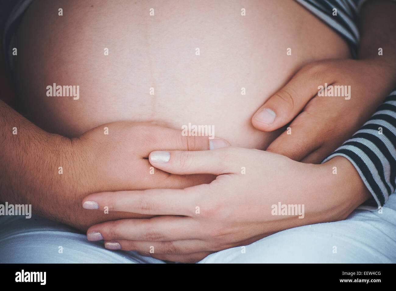 men holds hands on belly of pregnant women no face Stock Photo