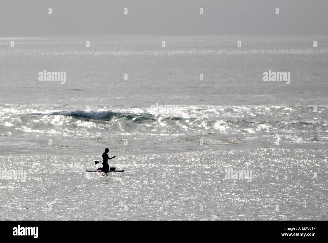 Paddle Boarder Silhouetted on the Ocean Stock Photo