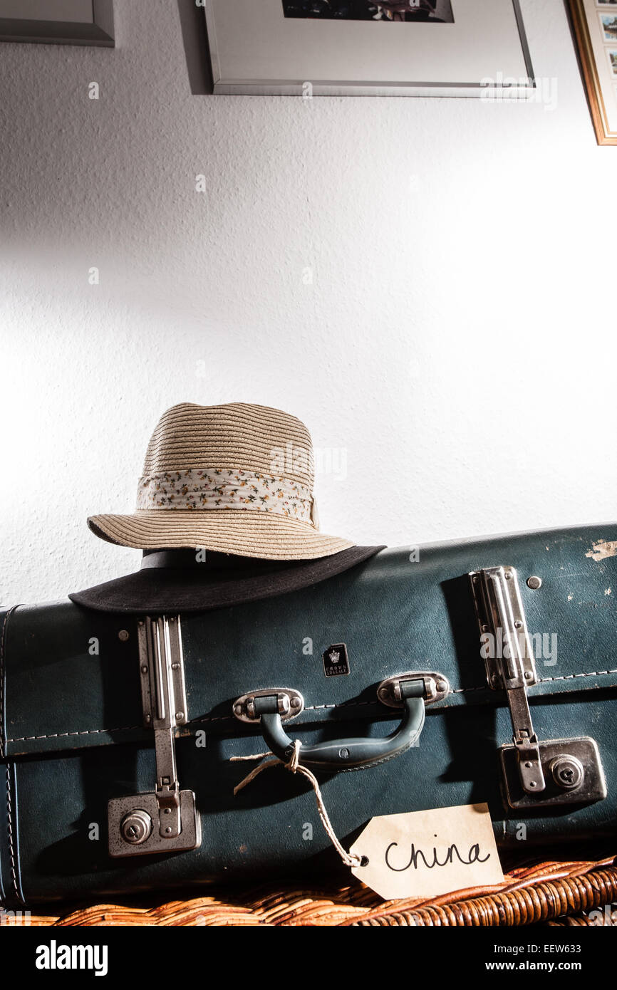 Vintage suitcase with china luggage tag.On top is a mans and womans hat. Stock Photo