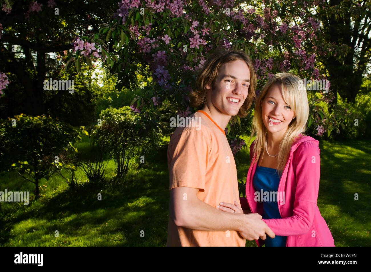 Couple holding hands in front of trees Stock Photo - Alamy