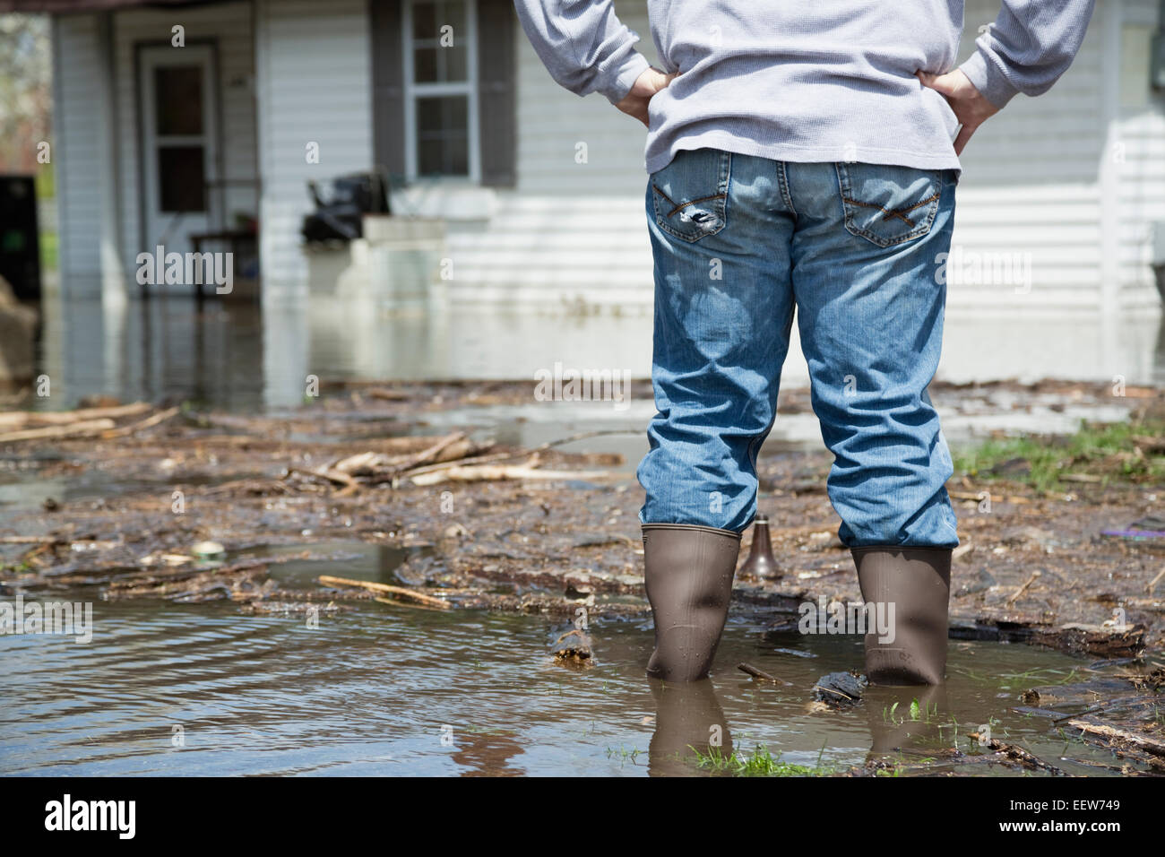 Man standing in front of flooded house Stock Photo - Alamy