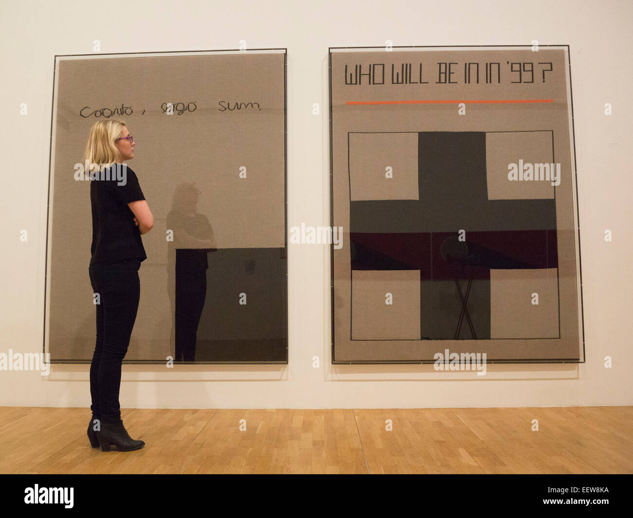 A Whitechapel employee looks at the Rosemarie Trockel artworks 'Cogito, ergo sum', 1999, and 'Who will be in in '99', 1988. The Whitechapel Gallery presents the exhibition Adventures of the Black Square, tracing a century of Abstract art from 1915 to today. Stock Photo