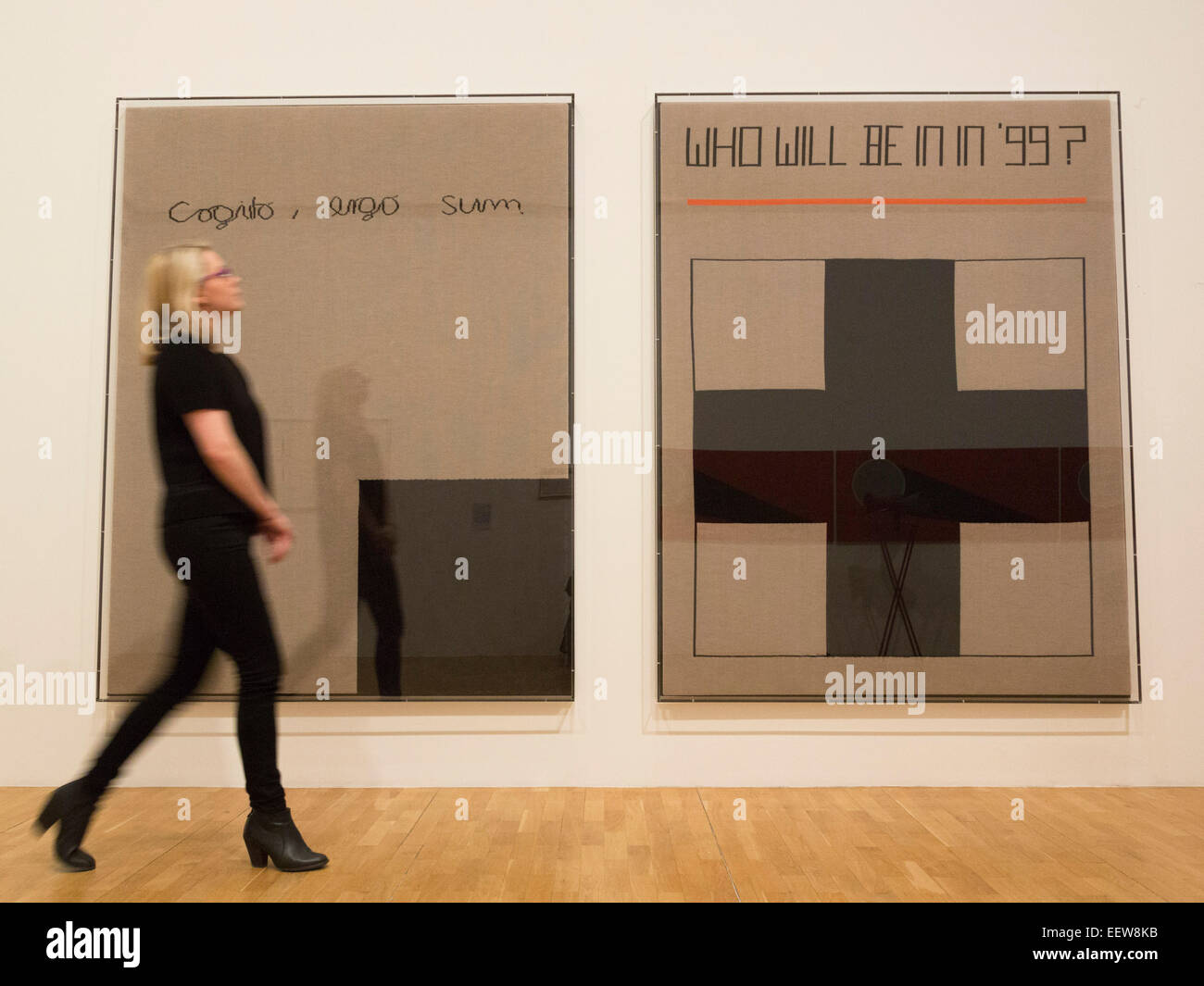 A Whitechapel employee looks at the Rosemarie Trockel artworks 'Cogito, ergo sum', 1999, and 'Who will be in in '99', 1988. The Whitechapel Gallery presents the exhibition Adventures of the Black Square, tracing a century of Abstract art from 1915 to today. Stock Photo
