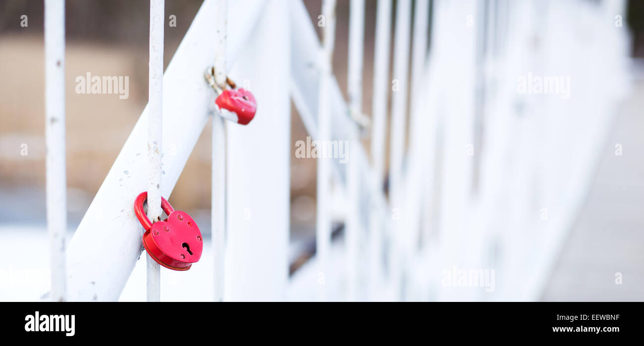 Red heart-shaped locks locked on fence of the white bridge Stock Photo ...
