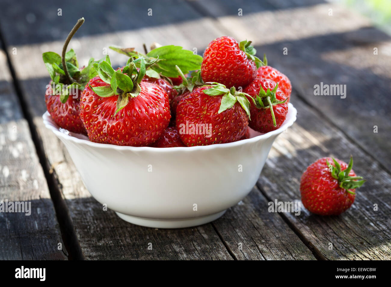 Fresh red strawberries in white bowl on old wooden table Stock Photo ...
