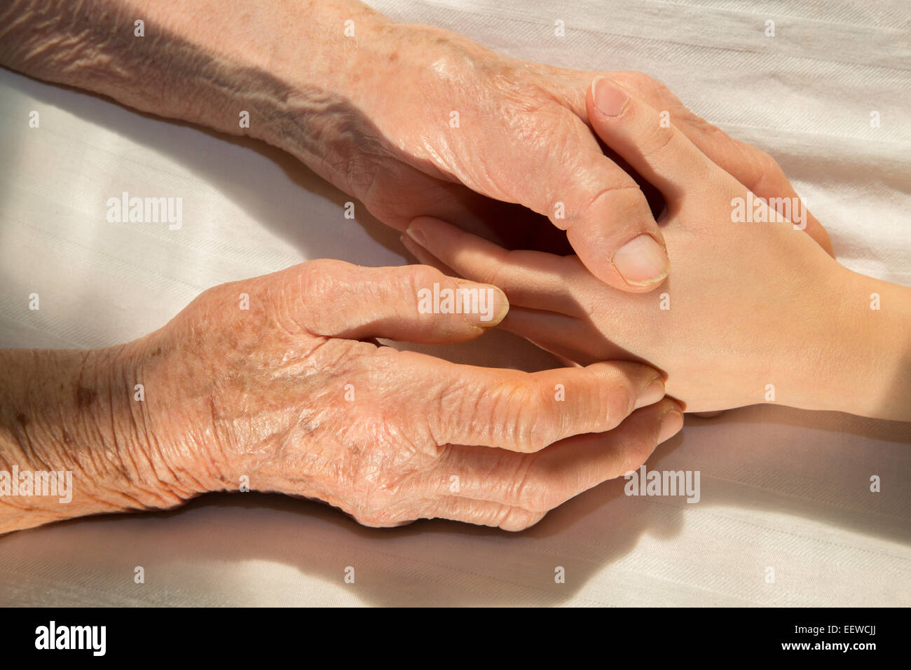 hands of grandmother and grandchild in the bed Stock Photo