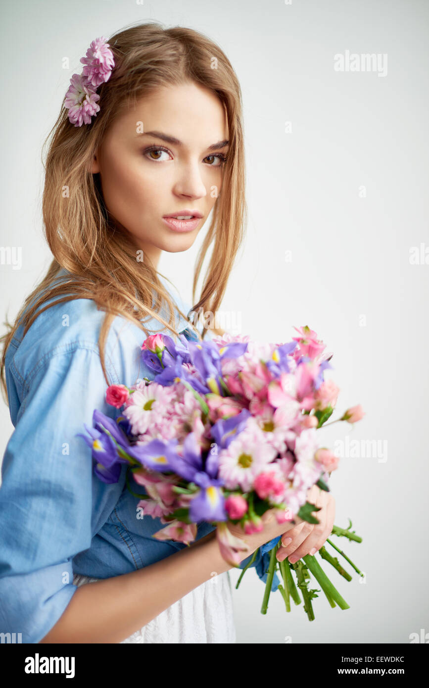 Pretty young lady with flowers looking at camera Stock Photo Alamy