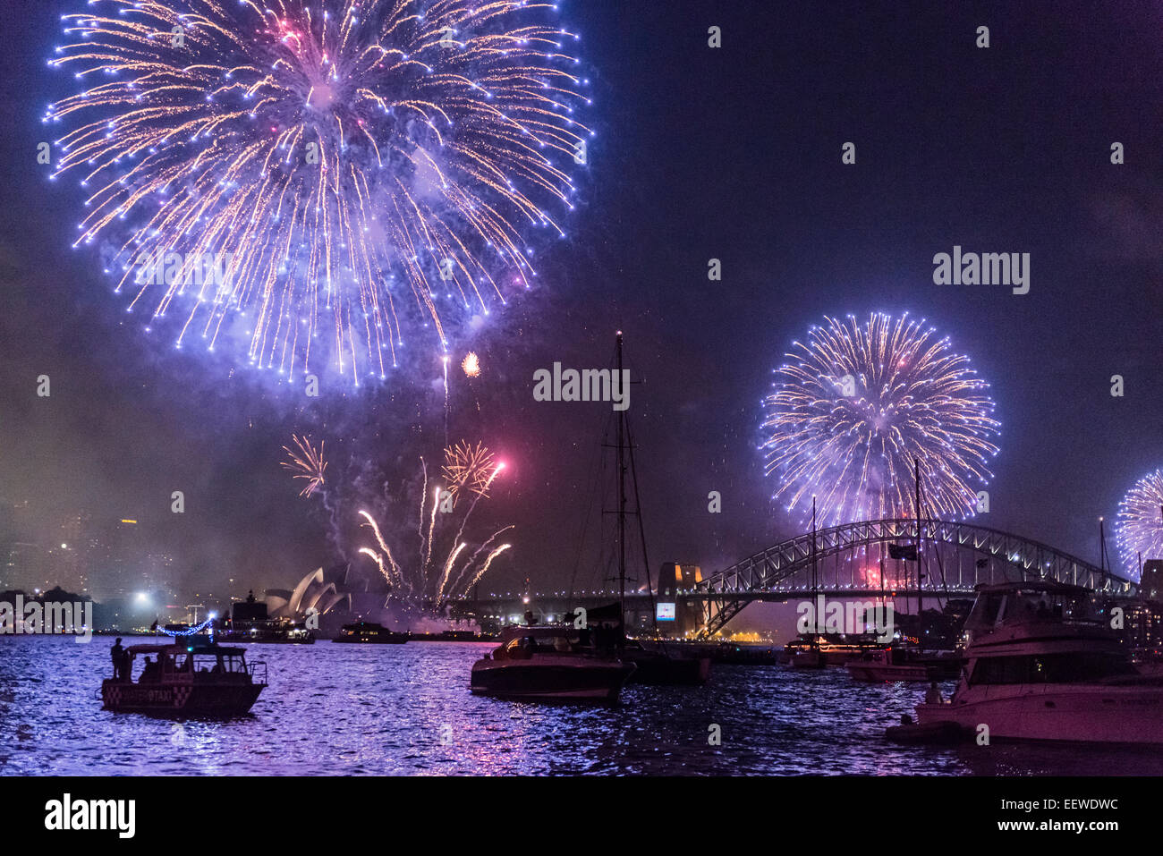 Family Fireworks Display over Sydney Opera House, Harbour Bridge and boats at anchor, New Year's Eve 2014, Sydney Australia Stock Photo