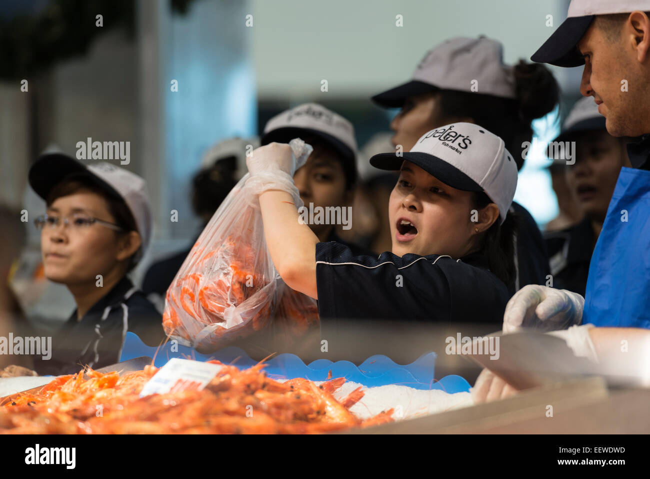 The prawn stall and a woman fishmonger holding a large bag of shell