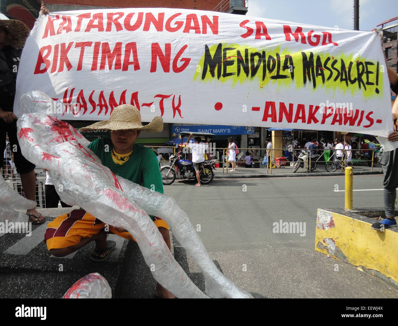 A Filipino protester carrying a 'wounded' dummy sits behind a banner that reads, 'Justice for the victims of Mendiola Massacre!', as they commemorate the 28th anniversary of the Mendiola Massacre that occured under the administration of President Benigno Aquino III's mother, former President Corazon Aquino, where thirteen farmers were killed. Anakpawis Partylist representative Fernando Hicap has filed a bill at Congress proposing to declare January 22, the anniversary of the Mendiola Massacre, a special holiday called 'Farmer's Day.' © Richard James Mendoza/Pacific Press/Alamy Live News Stock Photo