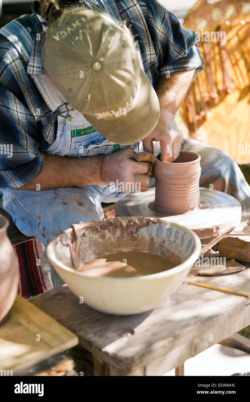 A North Carolina Potter 'throwing' clay on a pottery wheel Stock Photo