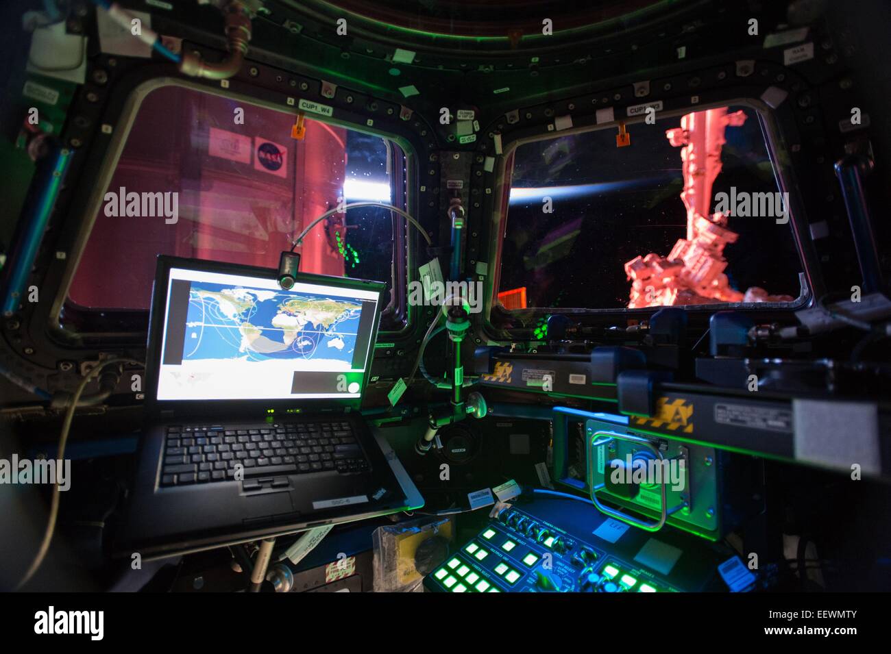 Interior view from the International Space Station Cupola module January 4, 2015 in Earth Orbit. The large bay windows allows the Expedition 42 crew to see outside. The Cupola houses one of the space station's two robotic work stations used by astronauts to manipulate the large robotic arm seen through the right window. The robotic arm, or Canadarm2, was used throughout the construction of the station and is still used to grapple visiting cargo vehicles and assist astronauts during spacewalks. The Cupola is attached to the nadir side of the space station. Stock Photo