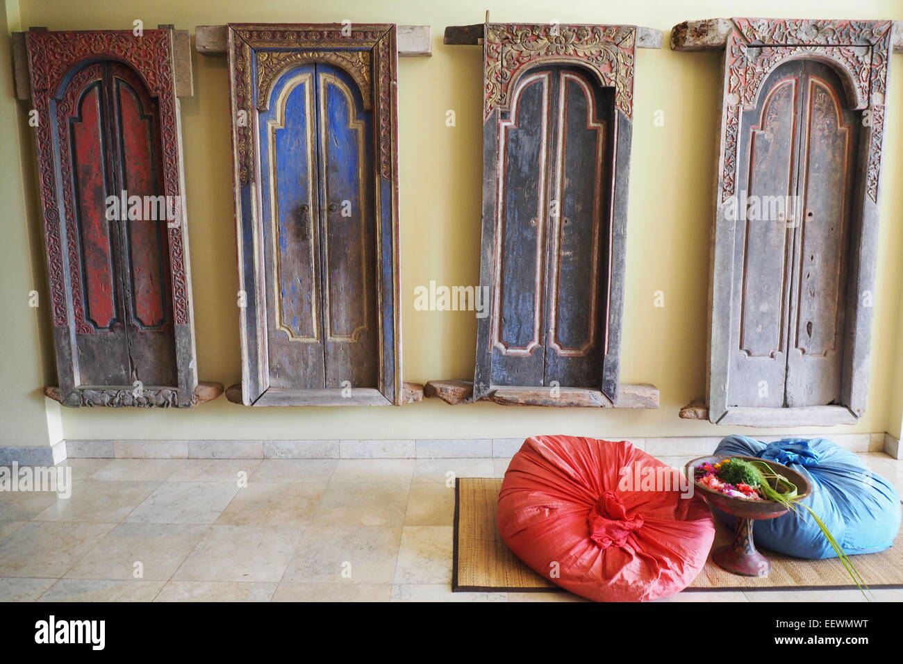 Four antique traditional Bali doors hanging on a wall. Stock Photo