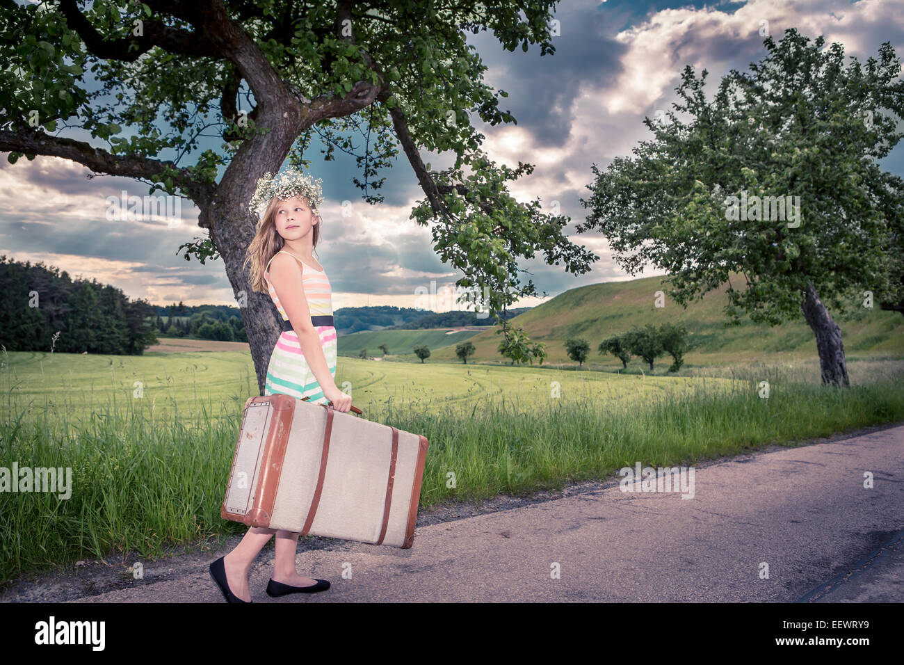 teenage girls on rural road with a suitcase Stock Photo