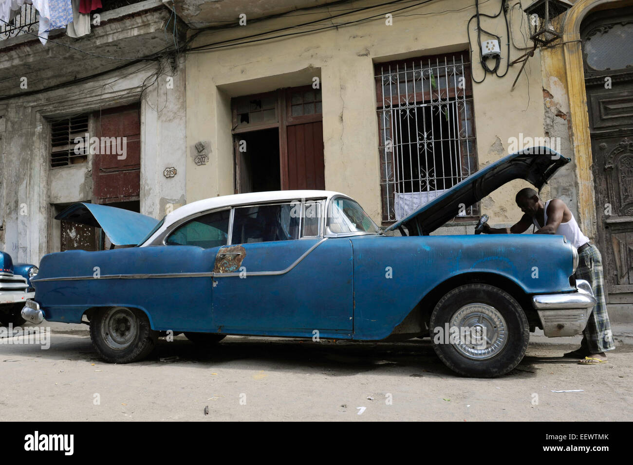 In der Altstadt von Havanna kontrolliert ein Mann seinen Oldtimer am Straßenrand, aufgenommen am 03.02.2012. Foto: Thomas Meinicke Stock Photo