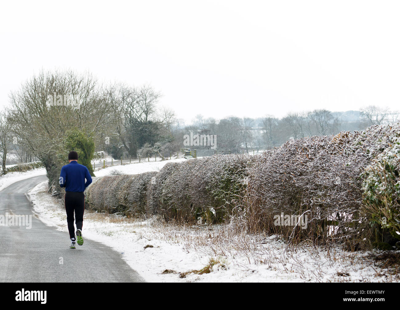 Whashton Green, North Yorkshire, UK. 22nd January, 2015. UK Weather: A jogger runs along a quiet road in North Yorkshire where freezing fog and black ice make it hazardous underfoot. © Robert Smith/Alamy Stock Photo